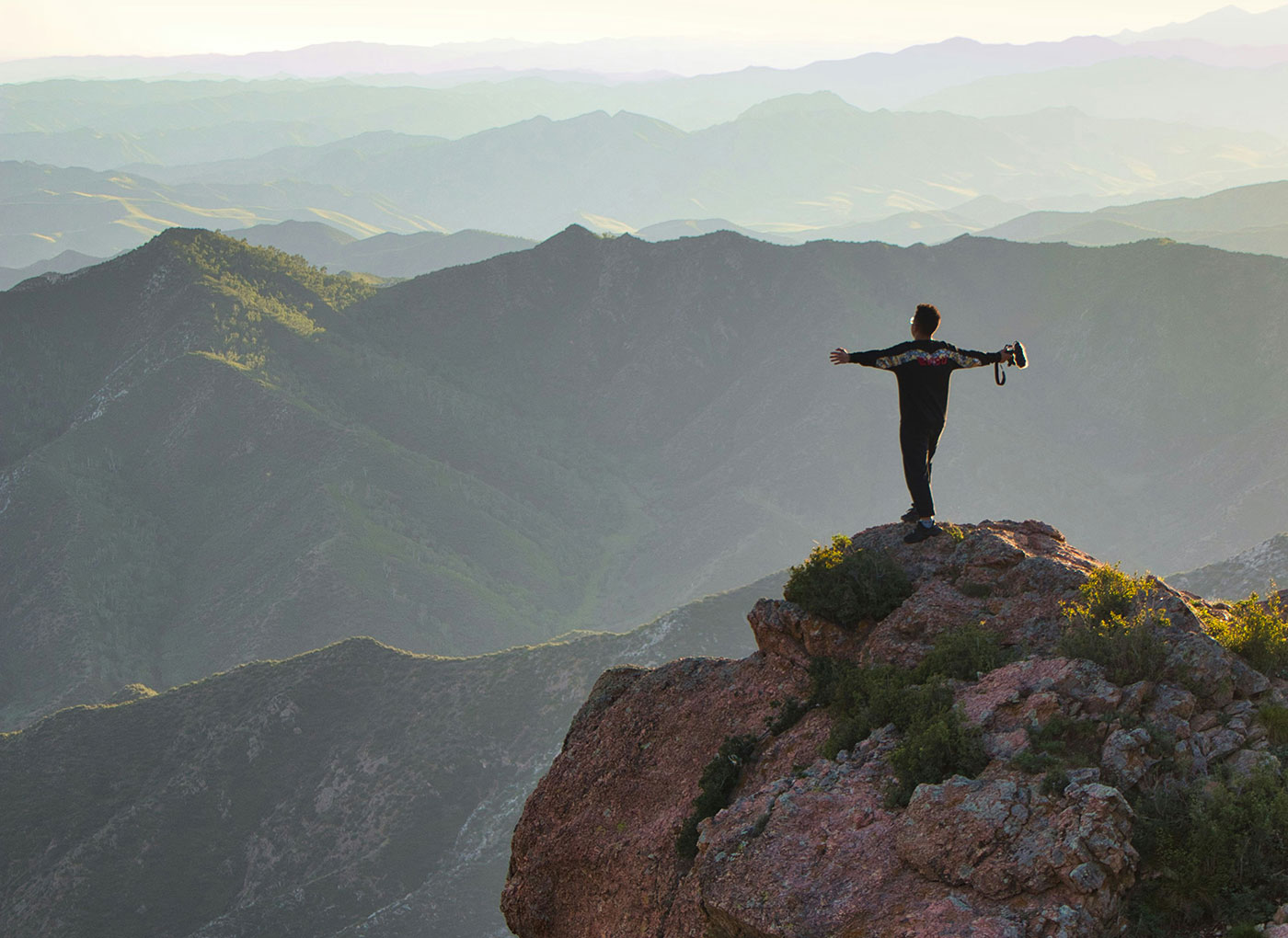 The image of a climber on the top of a mountain with a great view to represent that boldness in marketing is about accomplishment not just bravado for the sake of being different.